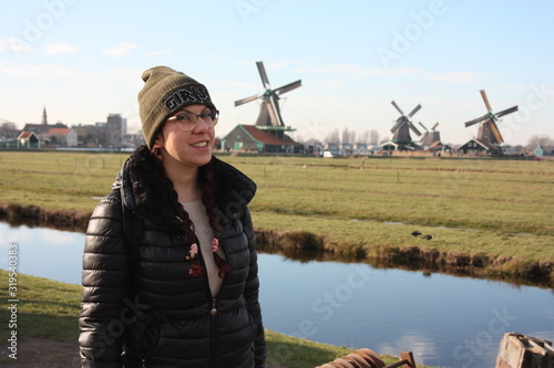 tourism in zaanse schan in the green dutch grasslands among the ancient windmills photo