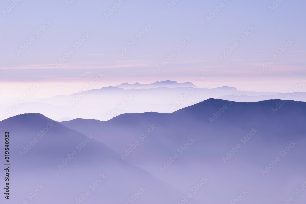 Fototapeta premium skyline of purple mountains in a misty dawn morning