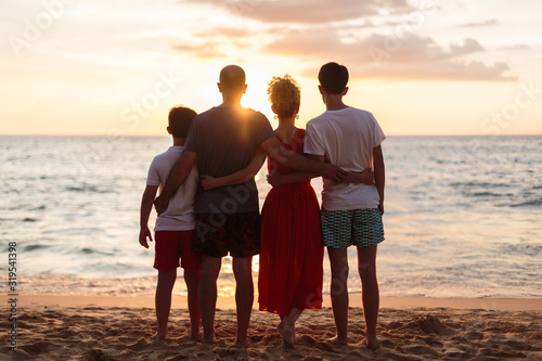 Obraz na płótnie Happy family standing on the beach on the dawn time w salonie