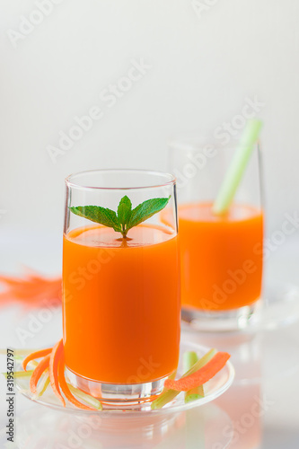 Freshly squeezed carrot juice with celery, vertical orientation