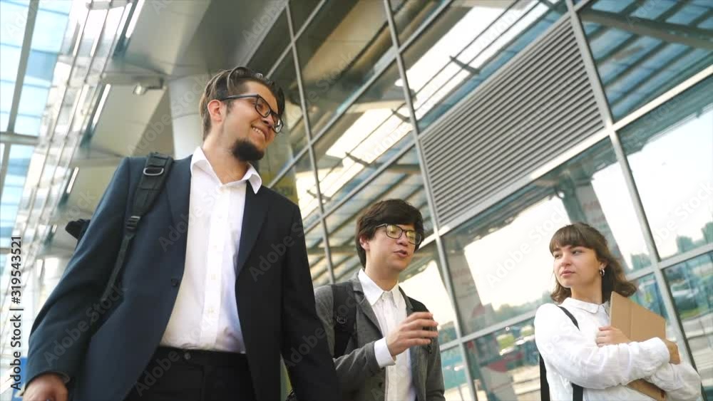Business team two men and woman walking together outside. Business team two men and woman walking together outside.