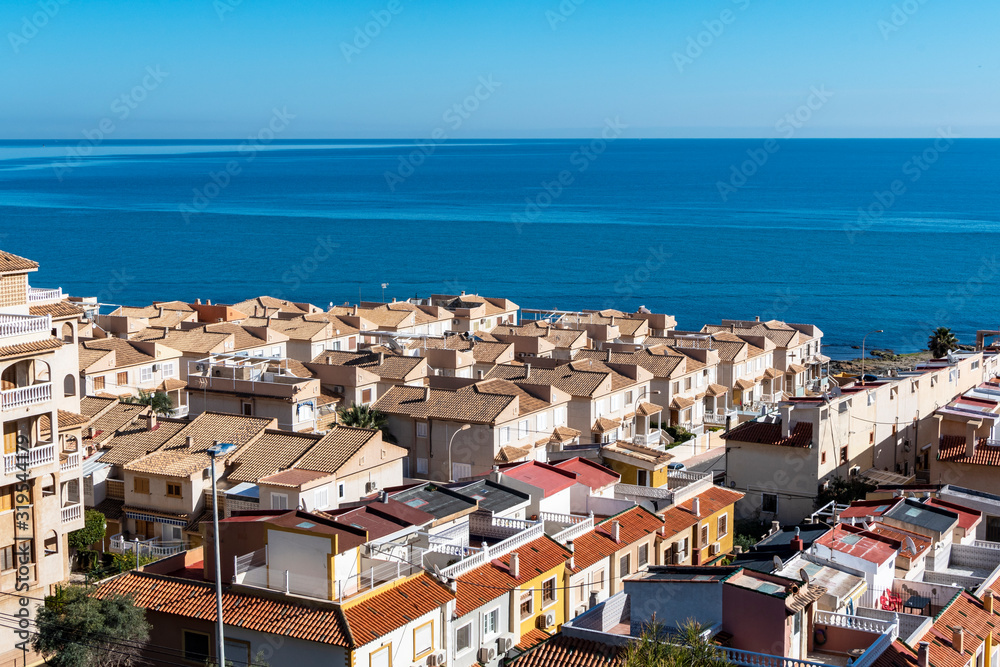 Blue sea and mediterranean houses with red roofs
