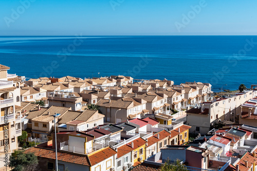 Blue sea and mediterranean houses with red roofs