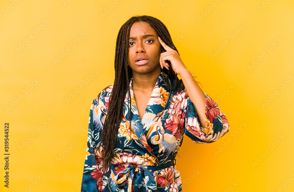 Young african american woman wearing an asiatic pijama isolated showing a disappointment gesture with forefinger. Young african american woman wearing an asiatic pijama isolated showing a disappointment gesture with forefinger.
