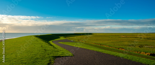  typical Dutch meandere dike with cycle path and view of the Wadden Sea photo