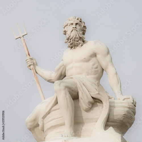 Close up mighty god of sea and oceans Neptune (Poseidon) against blue sky background. The ancient statue. photo