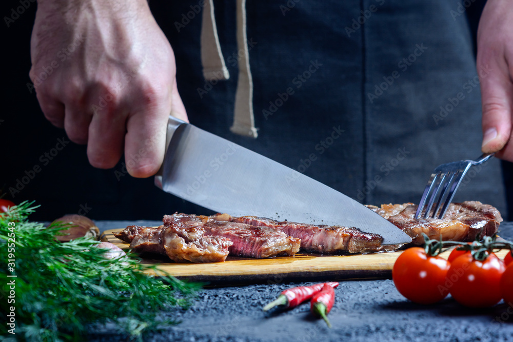 Freshly prepared steak is cut before serving. Selected medium-rare beef.