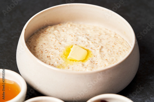 Healthy breakfast - milk rice porridge in a white plate on grey table background