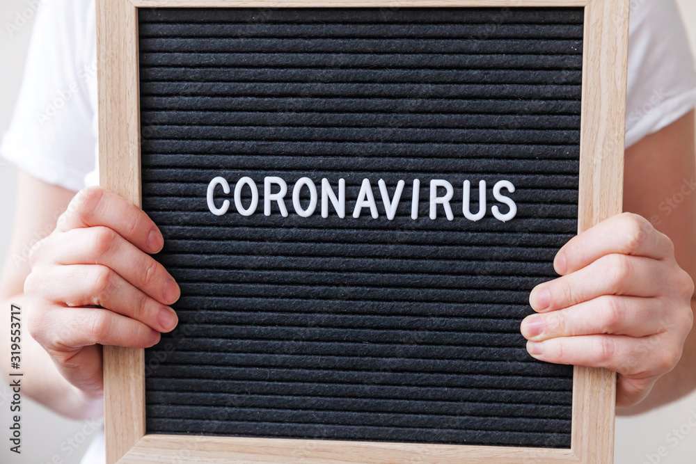 Woman hand holding black letter board with text phrase Coronavirus. Novel coronavirus 2019-nCoV, MERS-Cov middle East respiratory syndrome coronavirus originating in Wuhan China Woman hand holding black letter board with text phrase Coronavirus. Novel coronavirus 2019-nCoV, MERS-Cov middle East respiratory syndrome coronavirus originating in Wuhan China