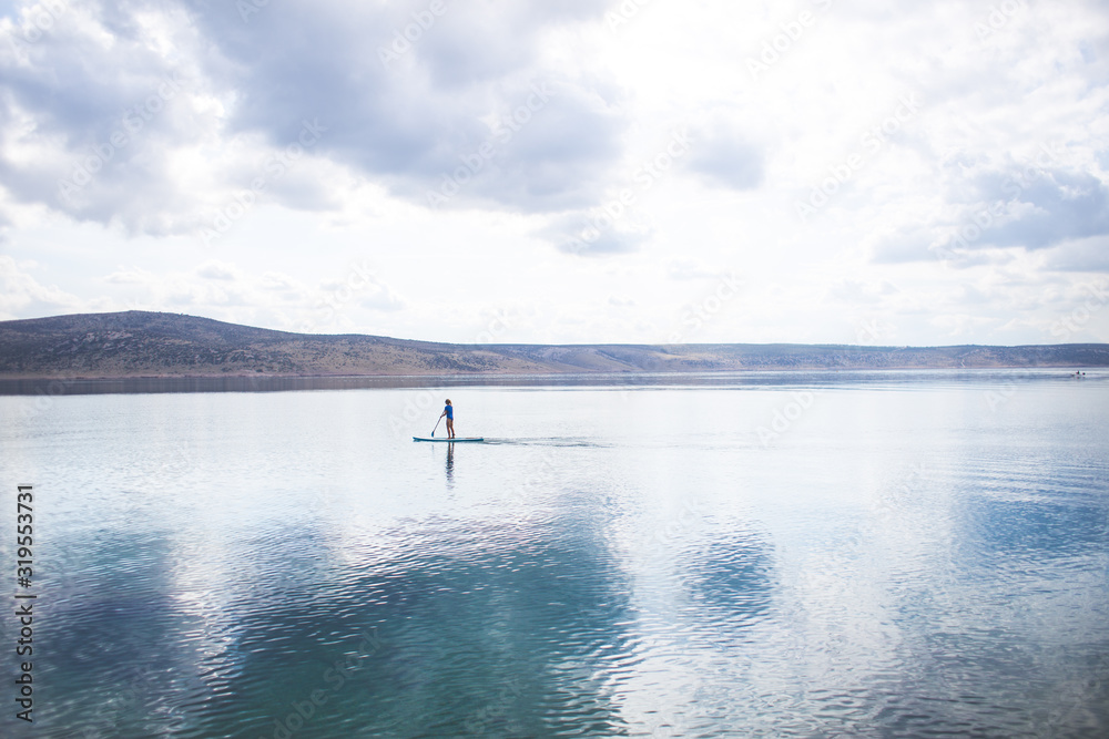 young woman SUP boarding