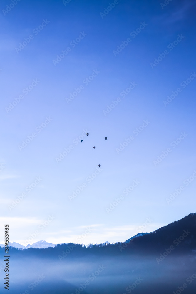 Air Balloons flying in blue sky over misty lake Lucern, Swirtzerland Air Balloons flying in blue sky over misty lake Lucern, Swirtzerland