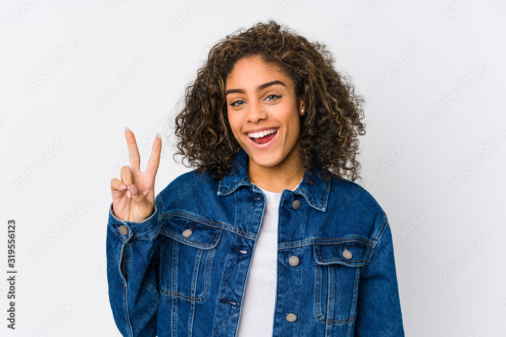 Young african american woman showing victory sign and smiling broadly. Young african american woman showing victory sign and smiling broadly.