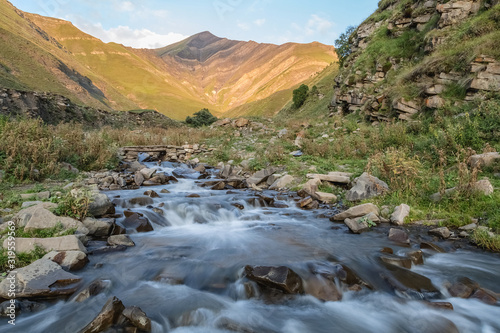 The river flows on a summer evening in the mountains. Mountain stream.