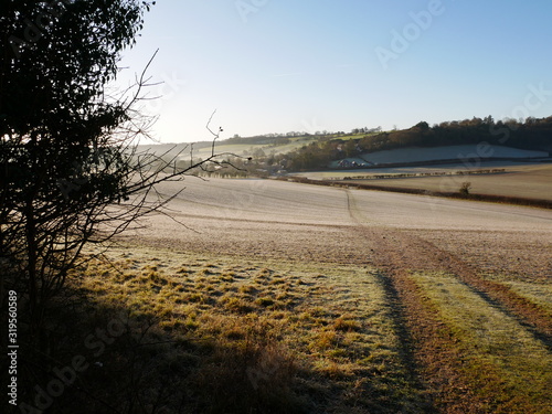 View of path leading across field towards Middle Assendon village in the Chilterns, Oxfordshire, in winter