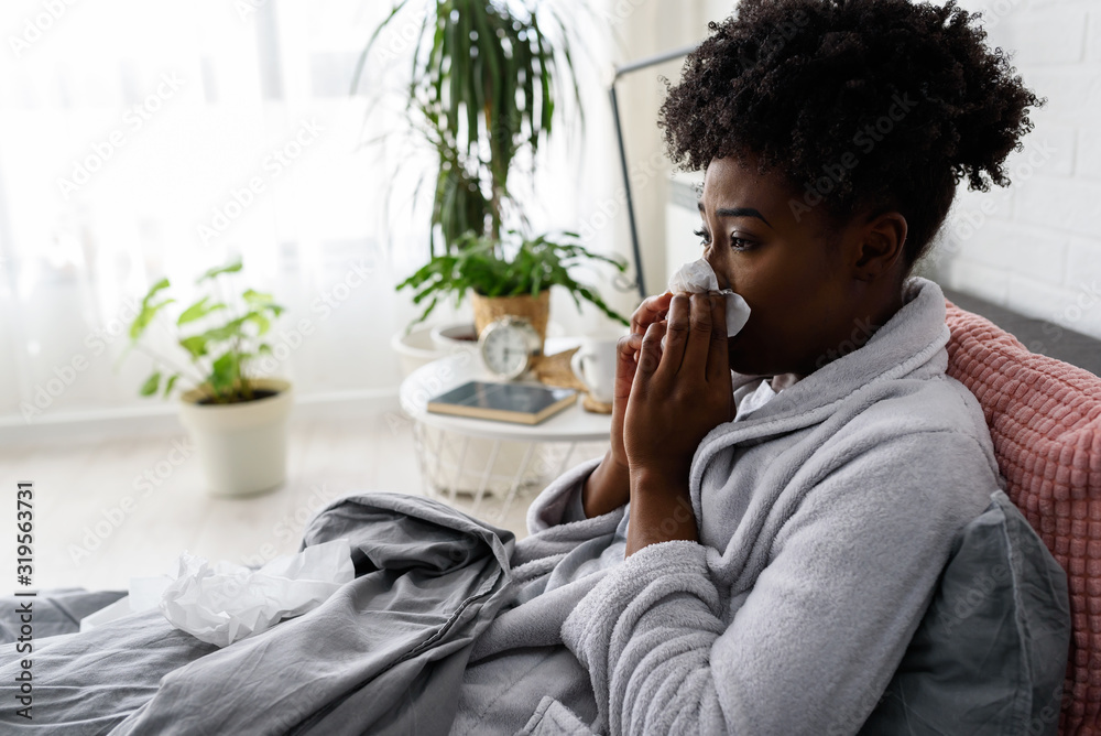Young African-American woman lying in bed at home. Feeling ill having flu. Young African-American woman lying in bed at home. Feeling ill having flu.