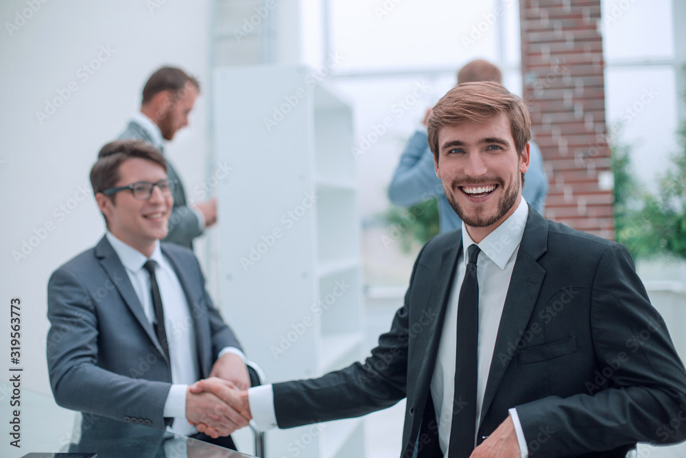 happy entrepreneur shaking hands with his business partner happy entrepreneur shaking hands with his business partner