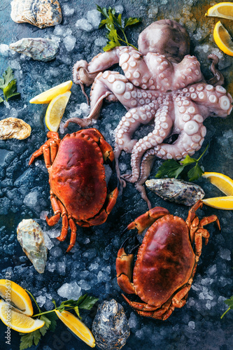 Zusammenstellung von Meeresfrüchten mit feinschmeckerischem Abendessenhintergrund der rohen frischen Krake,austern und mit roten krabben photo