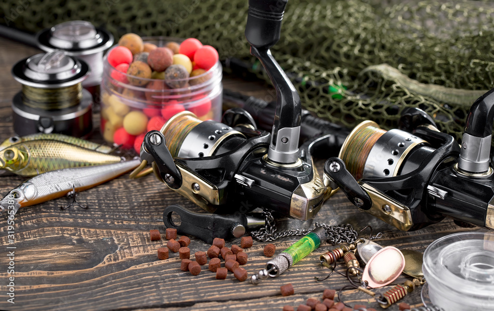 Fishing rods and spinnings in the composition with accessories for fishing on the old background on the table Fishing rods and spinnings in the composition with accessories for fishing on the old background on the table