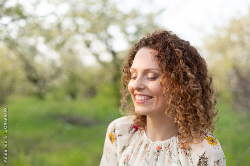 Close up portrait of young smiling attractive woman with curly hair in green flowering spring park. Pure emotions. Close up portrait of young smiling attractive woman with curly hair in green flowering spring park. Pure emotions.