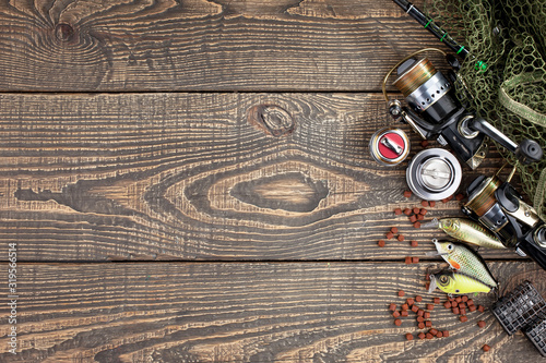 Fishing rods and spinnings in the composition with accessories for fishing on the old background on the table