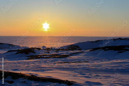 Beautiful sunset over an arctic landscape near Whale Cove, Nunavut. Taken during the winter month with snow on the ground.
