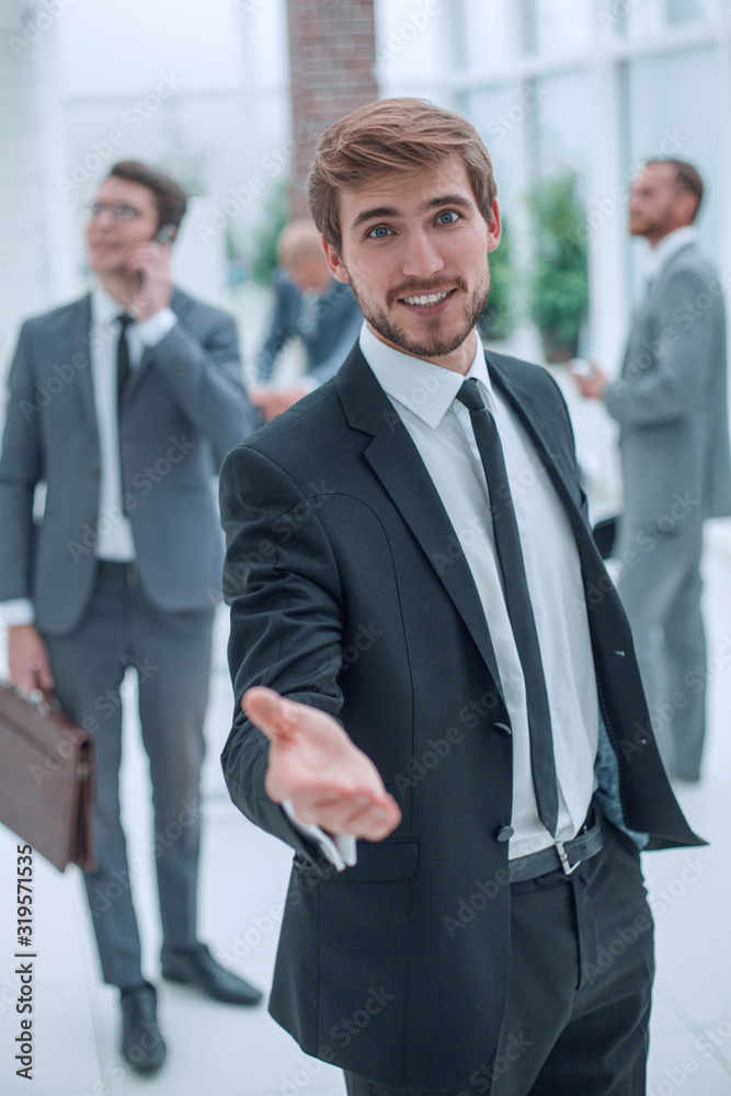 smiling business man holding out his hand for a handshake. smiling business man holding out his hand for a handshake.