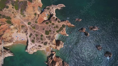 A magical aerial top view of the coast of beaches Vao Alemao, with tourists in Portugal Algarve Portimao.