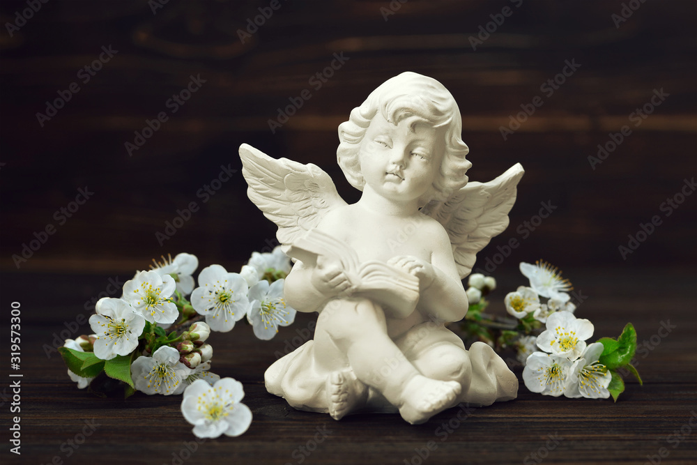 Guardian angel and spring flowers on wooden background Guardian angel and spring flowers on wooden background