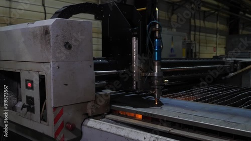 automated laser cutting of metal with more sparks in a poorly lit room