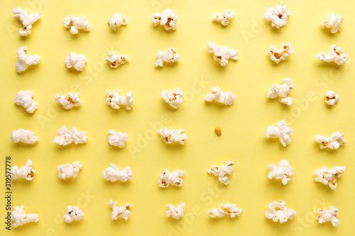  Flat lay of various forms of tasty salted popcorn and one grain of corn on yellow background
