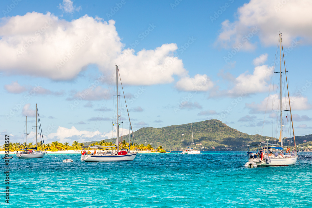 Turquoise sea and anchored yachts at Sandy beach island, near Carriacou island, Grenada, Caribbean sea