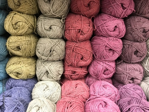 Texture of skeins of fine wool yarn in purple, gray and pink tones. Take a photo with store lighting. 