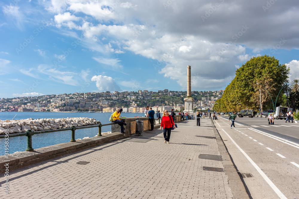 Italy, Naples, 7 October 2019, blonde tourist poses on the waterfront