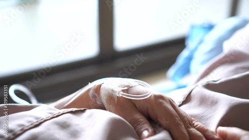 Patients saline, Iv drip, young woman hand with medical drip intravenous needle, give salt water on hospital bed. intravenous therapy (IV) is a therapy that delivers fluids directly into vein.