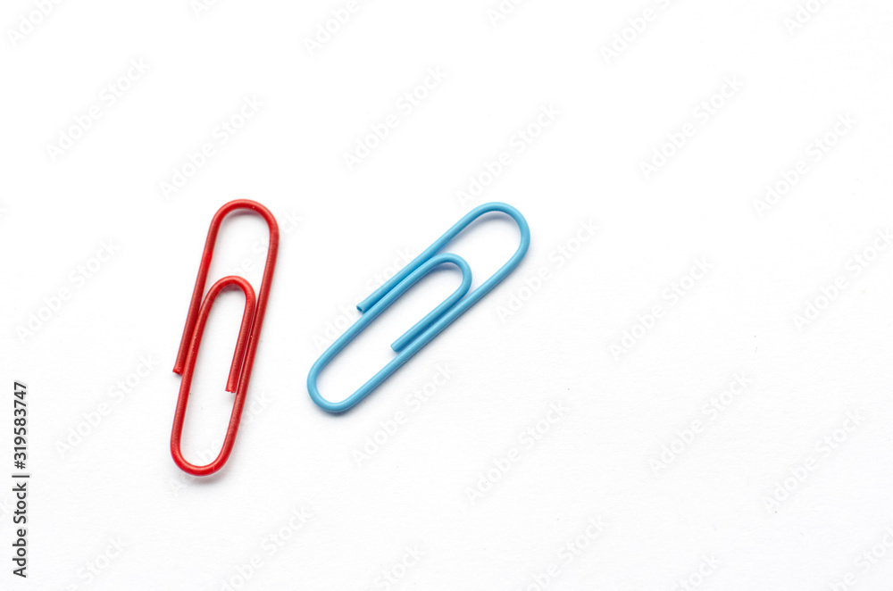 Pair of paper clips, red and blue, on white background Pair of paper clips, red and blue, on white background