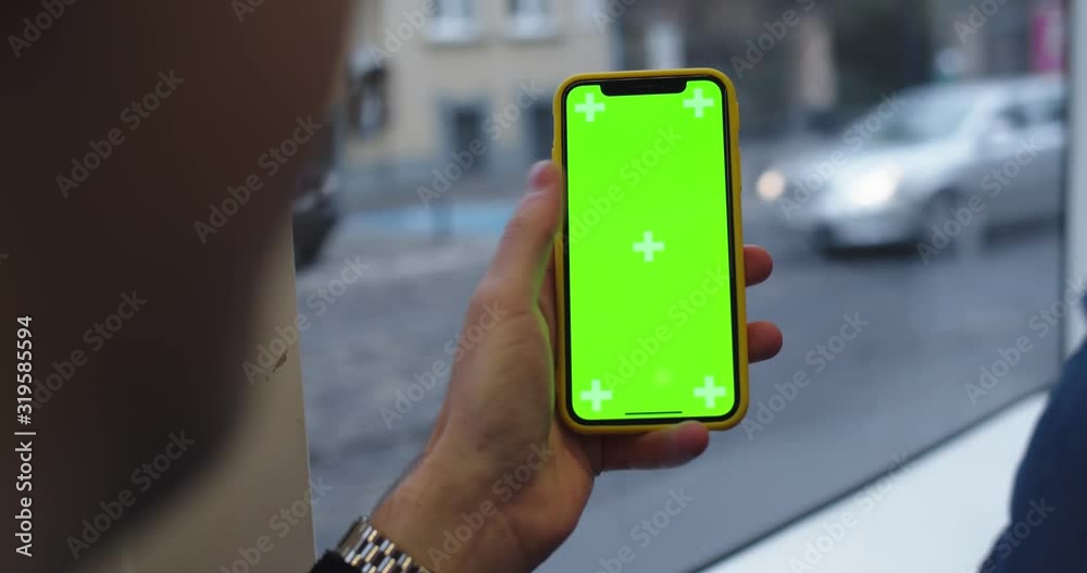 Close up of the male Caucasian hand holding vertical smartphone with ...