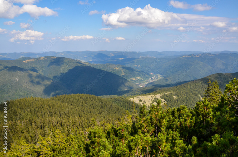 Mikulichyn village in the valley of the Carpathian Mountains view from the top of Mount Khomyak at an altitude of 1542 meters. Hutsul wooden houses at the foot of the mountains. Ukraine