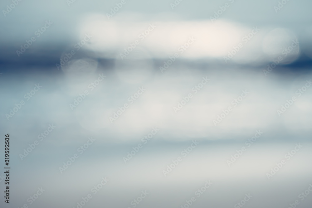 Blur tropical nature clean beach and white sand in summer with sun light blue sky and bokeh.