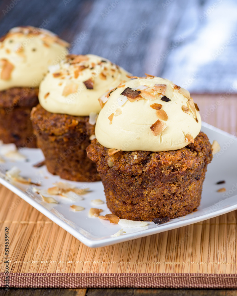 Three Vegan Apple, Walnut, Sultana and Coconut cupcakes, on a white plate.