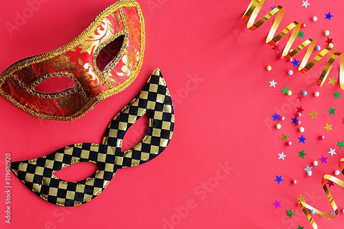 Festive masks with decor on a red background. Carnival celebration concept, Mardi Gras, Brazilian carnival, Venice Carnival, carnival costume, spring. Flat lay, top view, place for text