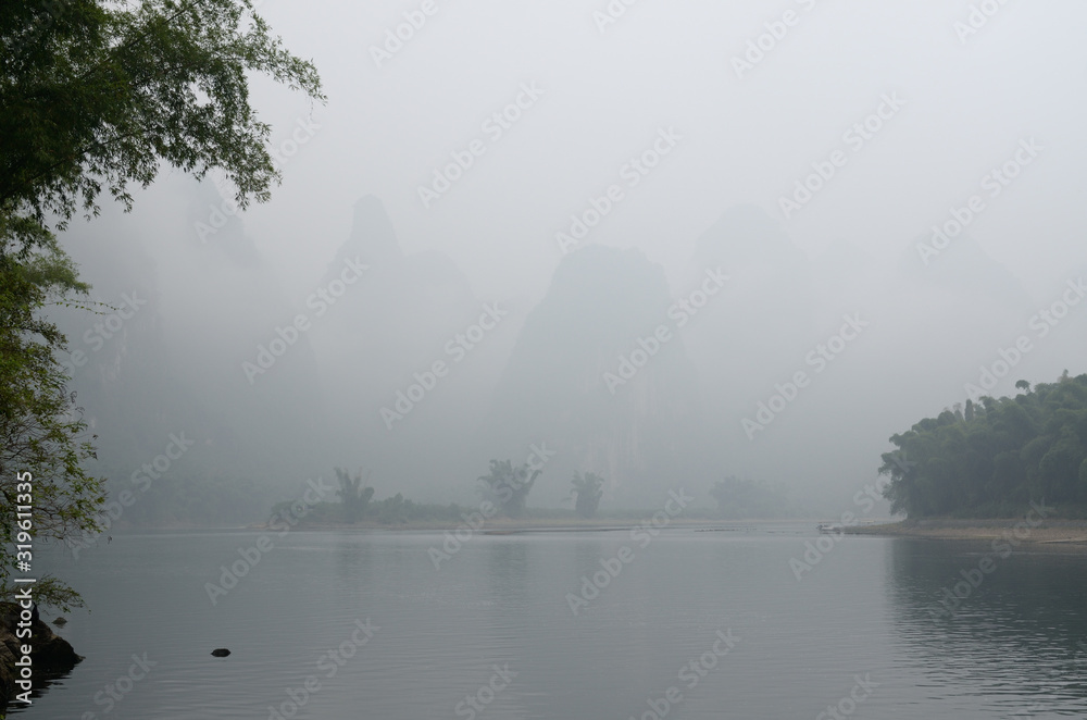 Karst limestone peaks in mist on the Li river in Huangbutan region near Xingping China