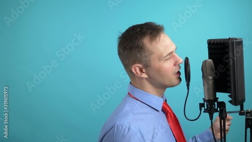 handsome young man in a tie singing into a microphone. closeup photo