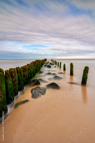 Fototapeta Naklejka Na Ścianę i Meble -  Baltic Sea, Debki town, Poland - fortifications on the beach shore against the sea waves