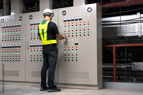 Electrical Engineer team working front HVAC control panels, Technician daily check controls system for security functions in service room at factory. Heating,Ventilation,Air Conditioning.