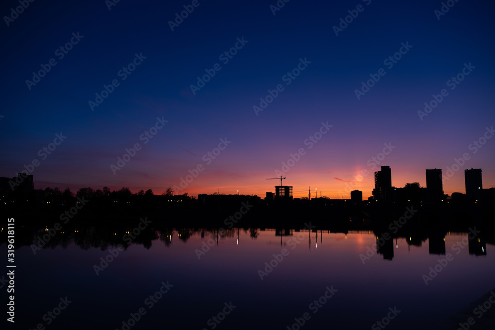 Sunrise in a big city over a river against a blue sky
