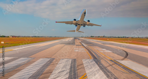 A Passenger airplane fly up over take-off runway from airport