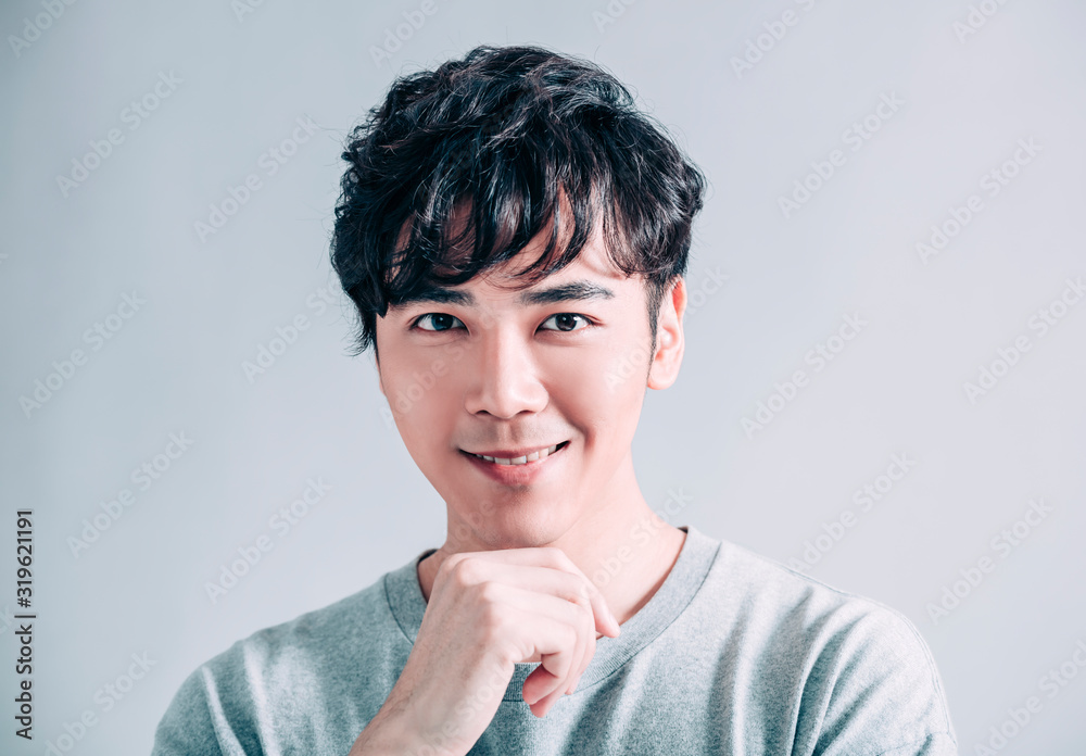 portrait of young smiling handsome man isolated on gray background portrait of young smiling handsome man isolated on gray background