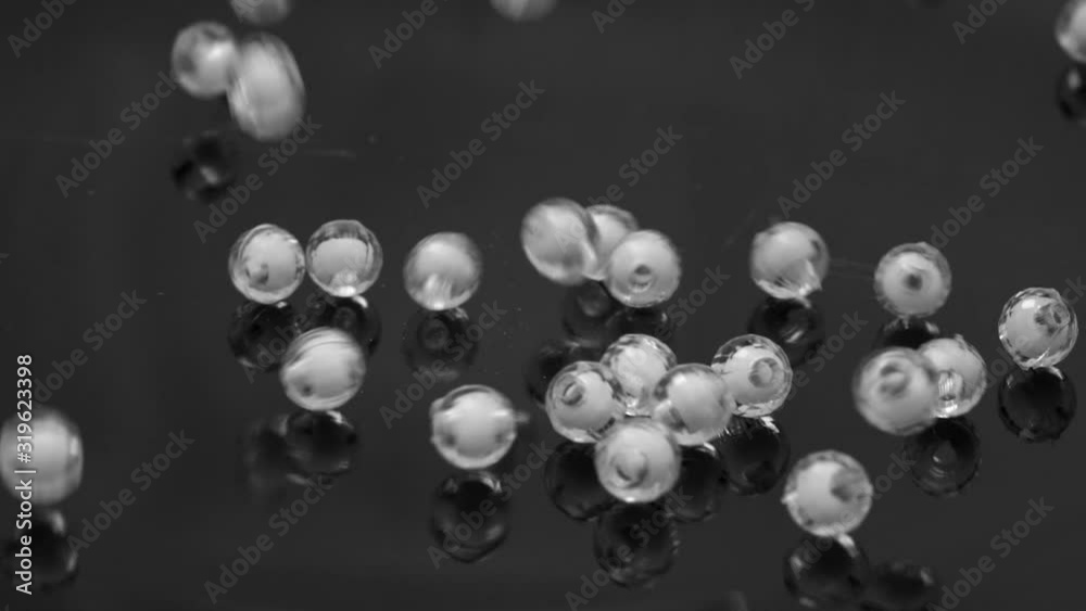 white beads bouncing on the black background. white beads bouncing on the black background.