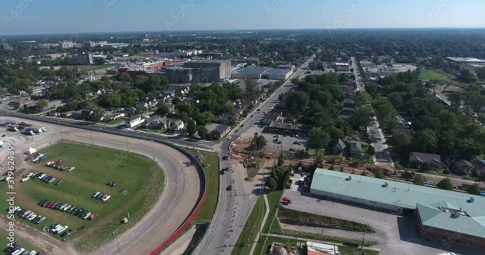 Aerial Over Racetracks With Demolition Derby Towards Factory With Solar Panels in Distance Aerial Over Racetracks With Demolition Derby Towards Factory With Solar Panels in Distance