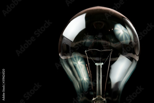 Incandescent light bulb on a black background